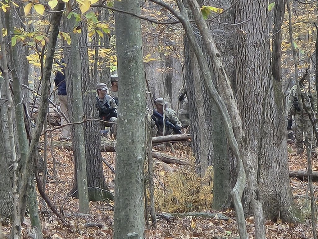 Cadets in formation hiding among the trees